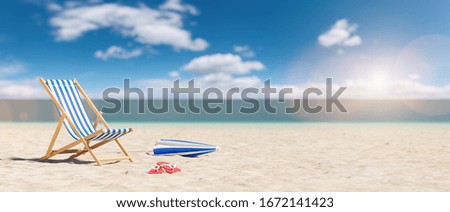 Beach chair with flip-flops and umbrella on empty sand. Beach with blue sky in summer as vacation, copy space for individual textconcept 