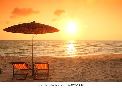 Liegestuhl am Strand mit Sonnenuntergang