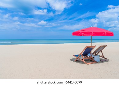 Beach Chair With Red Umbrella On Tropical Beach In Blue Sky.