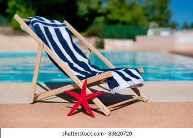 Beach Chair With Towel Near The Swimming Pool