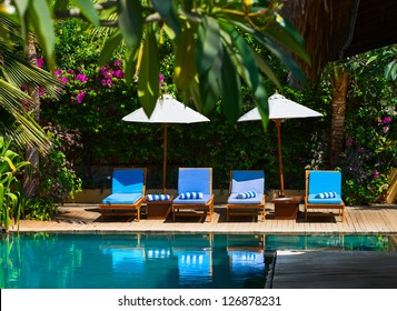 Beach Chairs Near Swimming Pool In Tropical Resort