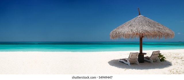 Beach Chairs and Umbrella on a beautiful island, panoramic view with much copy space