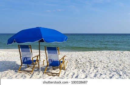 Beach Chairs And An Umbrella On The Gulf Coast.