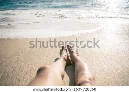 Ať the beach chilling, legs in the sand