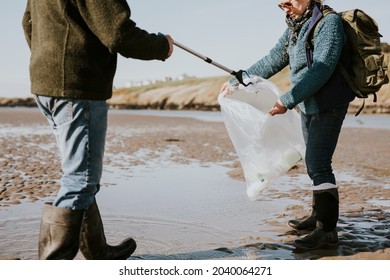 Beach cleanup volunteers picking up trash for environment campaign - Powered by Shutterstock