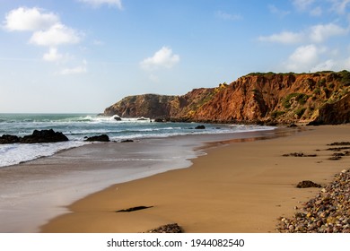 Beach with clear water and red cliffs in Algarve, Portugal - Powered by Shutterstock