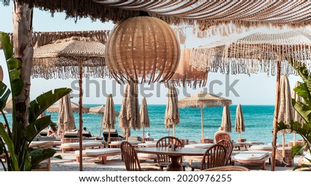 Beach  club view, modern white sun beds, knitted makrome umbrellas for sun protection, sea on background, food corner tables, straw decoration natural Stock photo © 