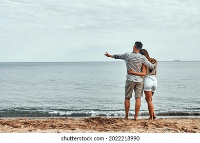 Beach Couple Walking On Romantic Travel Honeymoon Vacation Summer Holidays Romance. Back View Of Casual Happy Lovers In Full Body Length On Beach. Copy Space