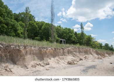 Beach With Dune Erosion And Greenery Under A Blue Sky With Clouds In Bridgman, Michigan After Storm Damage.