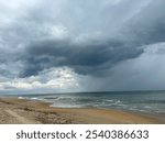 Beach and dunes with dark stormy clouds, blue sky, gray clouds, sand dunes, ocean, waves