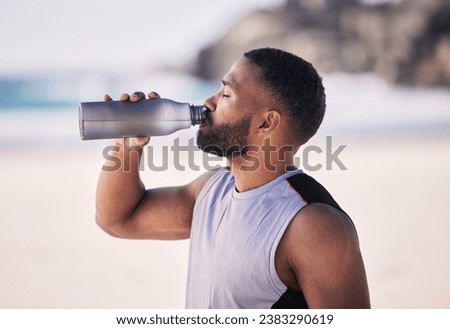Beach, exercise and man drinking water after running, workout or cardio fitness for health. Hydration, drink and thirsty male and runner person with bottle at sea for training, wellness or sports