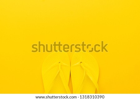 beach flip-flops on the yellow background with copy space. summer concept