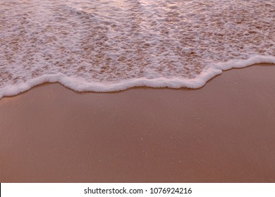 The beach has white bubble waves with sand