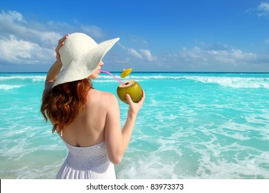 beach hat profile girl drinking a coconut fresh cocktail in tropical Caribbean sea