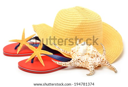 Beach hat, red flip flops with starfishes and a seashell isolated on white