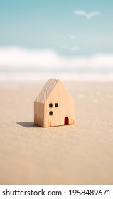 Beach House Concept. Mini Wooden House On The Sand Beach. Destination For Vacation Or Retirement Life. Summer Sunny Day. Metaphor Photo