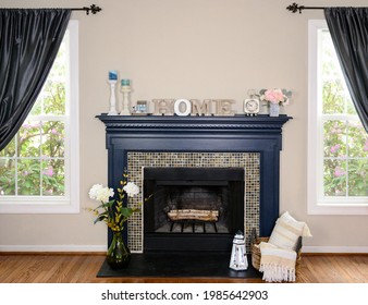 Beach House Decor, Living Room Background, Blue Fireplace, Home Decor, Flower Base, Table Clock, Wax Candles, Lighthouse Lantern, Gray Wall, And Windows With Curtains