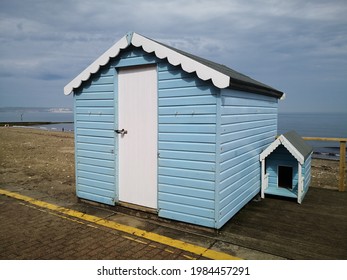 Beach Hut And A Matching Dog House On The Coast Of England