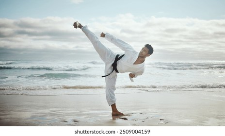 Beach, karate and man with fitness, kick and ocean with nature, wellness and balance. Healthy person, seaside and guy with training, skills and practice with professional, martial arts and taekwondo - Powered by Shutterstock