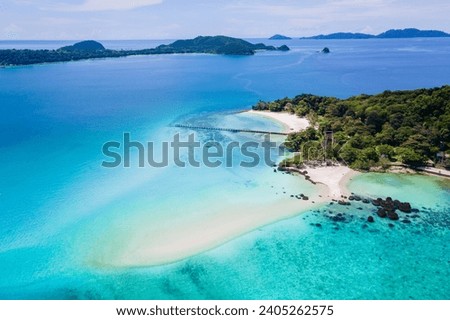 beach of Koh Kham Island Trat Thailand, aerial view of the tropical island near Koh Mak Thailand. white sandy beach with palm trees and big black boulder stones in the ocean
