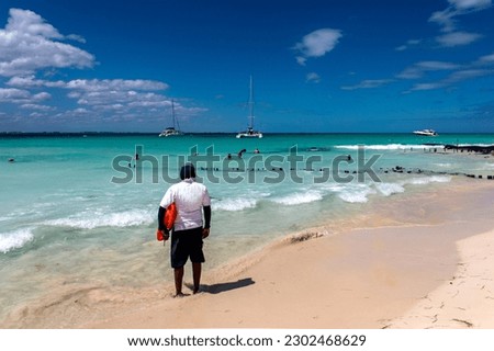 Beach lifeguard attentive to people bathing in the turquoise Mexican Caribbean waters. Beach lifeguard on the beach of island women in Mexico. Beach lifeguard concept.
