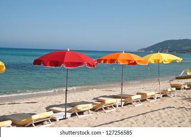Beach Loungers And Parasol On The Beach Of St. Tropez, France.