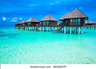 beach in Maldives with few palm trees and blue lagoon - Shutterstock ID 382024579