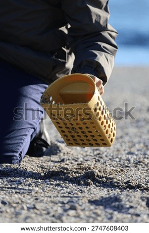 Beach metal detecting. A metal detector in hand in nature, a seascape during the cold season. High quality photo