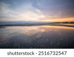 Beach in the morning. Sunrise, pebble beach on a rocky coast. The sky is reflected in the water of a bay. Natural spectacle of a Mediterranean landscape, island of Vir, Zadar, Dalmatia, Croatia, Adria