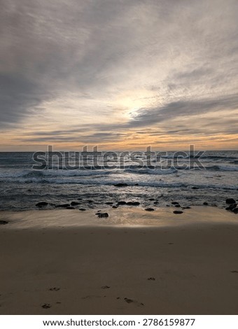 beach ocean sunset with whispy clouds and wet sand golden hour colors blue orange green 