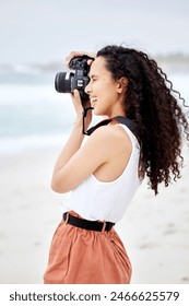 Beach, outdoor and woman with camera for photography, nature scenery and vacation travel with happy memory. Girl, ocean and photographer with DSLR lens for cinematic shot and sea picture in Australia