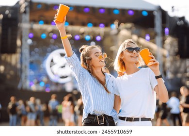 Beach party. Two young woman with beer at music festival. Summer holiday, vacation concept. - Powered by Shutterstock