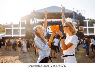 Beach party. Two young woman with beer at music festival. Summer holiday, vacation concept. - Powered by Shutterstock