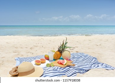 Beach picnic with lemonade and fruits (Cantaloupe, slice of watermelon, pinapple, mango, kiwi and grapefruit)