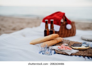 Beach Picnic With Shripms, Beer, Candles And Santa Hat. Exotic New Year And Christmas