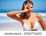 Beach portrait, happy woman and ok on eye for holiday, summer travel or vacation review. Ocean, girl and okay hand gesture for funny face, success or laugh for excellence with perfect bikini in Miami