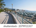 Beach promenade in Manfredonia, blue sky, umbrellas and loungers on the beach, Apulia region in southern Italy