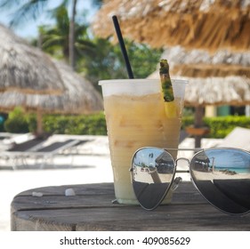 Beach Props Sunglasses And Tropical Drink Under Tiki Hut