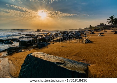 Beach with red sand and black rocks with a beautiful sunset in Congo Town, Monrovia, Liberia