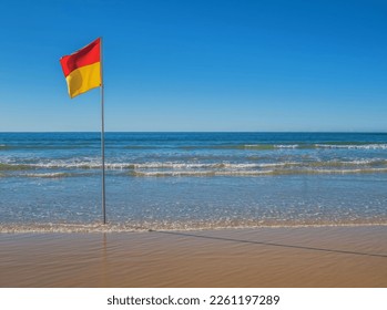 Beach with red and yellow safe swimming flag in Australia - Powered by Shutterstock