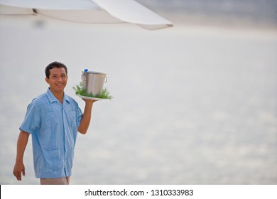 Beach Resort Waiter Holding Drinks In Ice Bucket