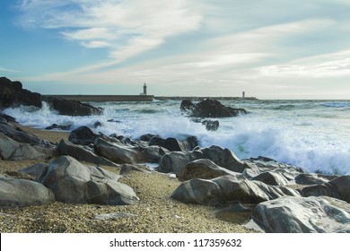 Beach with rocks and a cloudy sky.