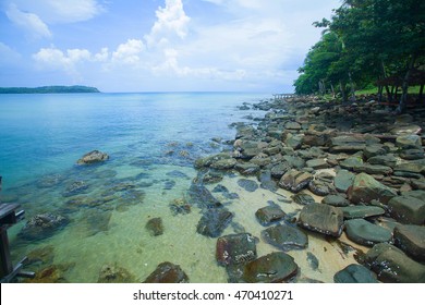 Beach with rocks and a cloudy sky.