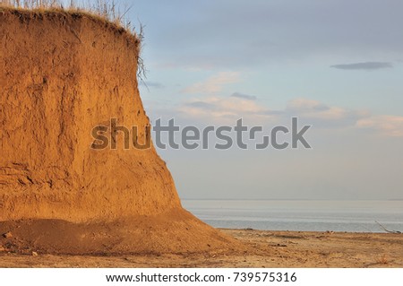 Beach with rocks and a cloudy sky.