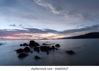 beach with rocks and waves; sunset background