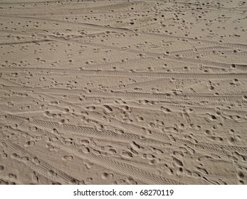 Beach Sand With Foot Prints And Tire Tracks On Santa Monica Beach. Texture Works Well As Abstract Background. Sand Pattern.