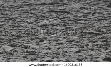 Beach sand with many footprints.