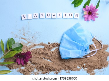 Beach Sand On A Blue Background With Wood Letters And A Word Staycation. Holiday At Home