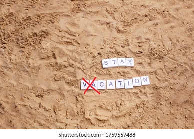 Beach Sand With Toys For The Baby, Water, The Word Holi Stay In Colored Letters. Staycation Content