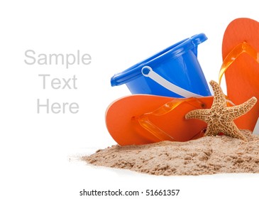 Beach Scene With Flipflops, Sand, Blue Bucket And Starfish On White With Copy Space